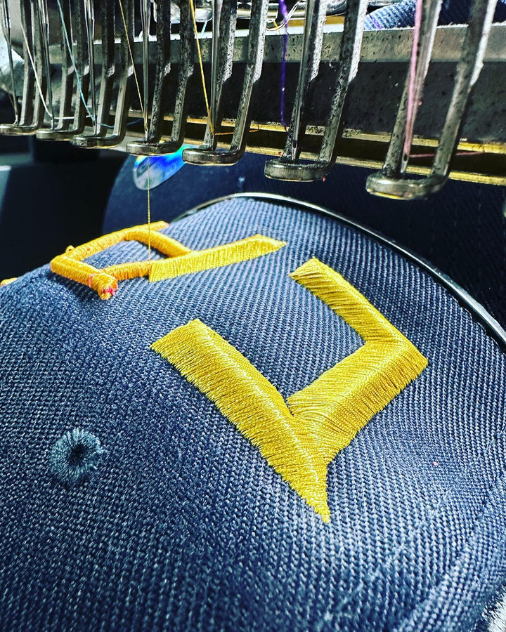 Embroidery hoop with blue fabric and yellow letter &