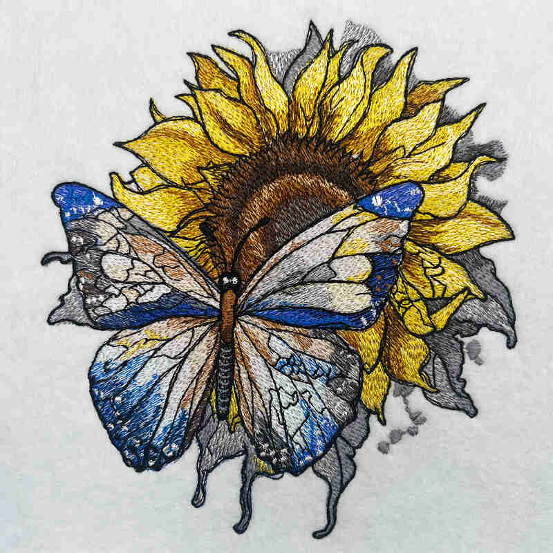 Embroidered jute tote bag featuring a sunflower with a butterfly on it, against a white background.