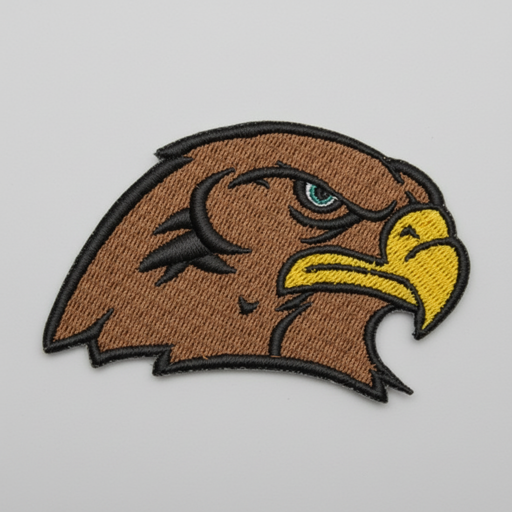 Embroidered Falcon head design on a grid background