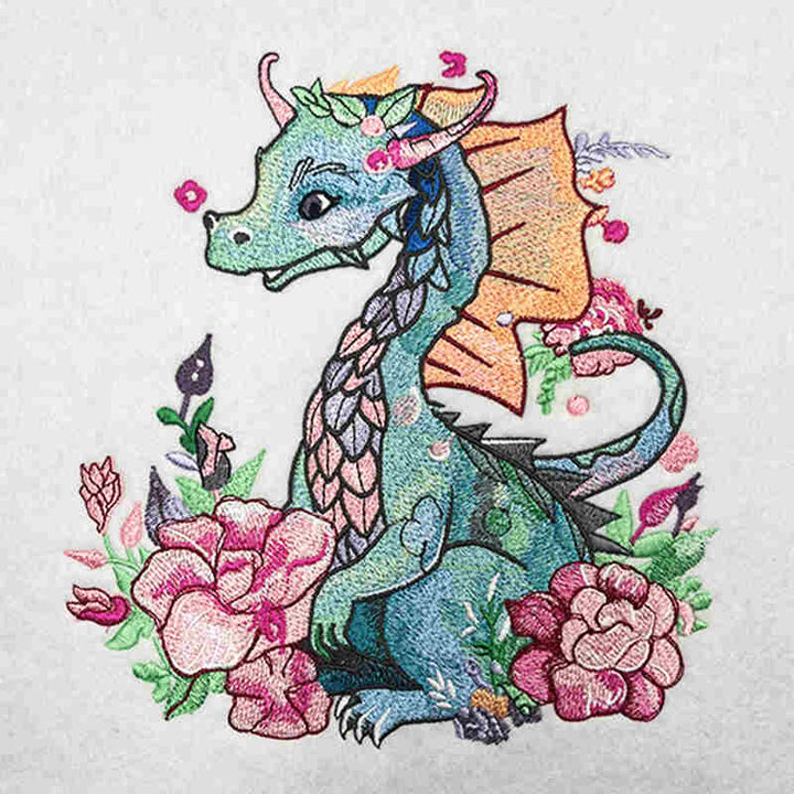A tote bag made of jute with vibrant embroidery of a dragon surrounded by floral designs.