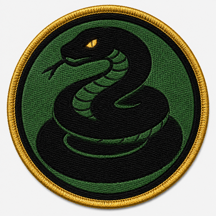 Basilisk Eye embroidery patch featuring a coiled snake with a glowing eye in flat green and black | Hand Finished in Dubai | EmbroMania