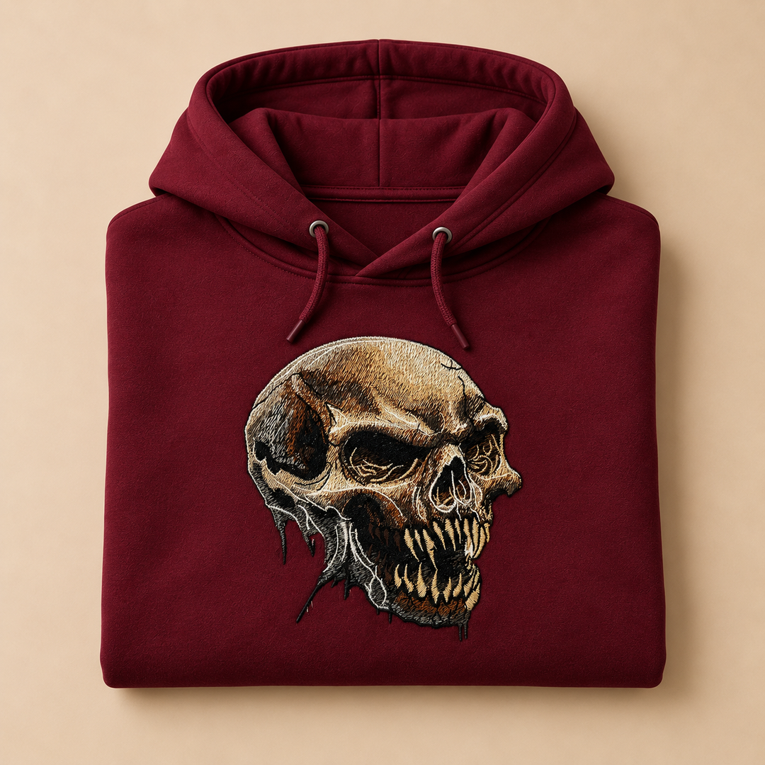 Feral Bonefang Skull Machine Embroidered Hoodie in Medium Burgundy – Bone-toned fanged skull design embroidered on burgundy 320gsm premium fleece | Hand Finished in Dubai