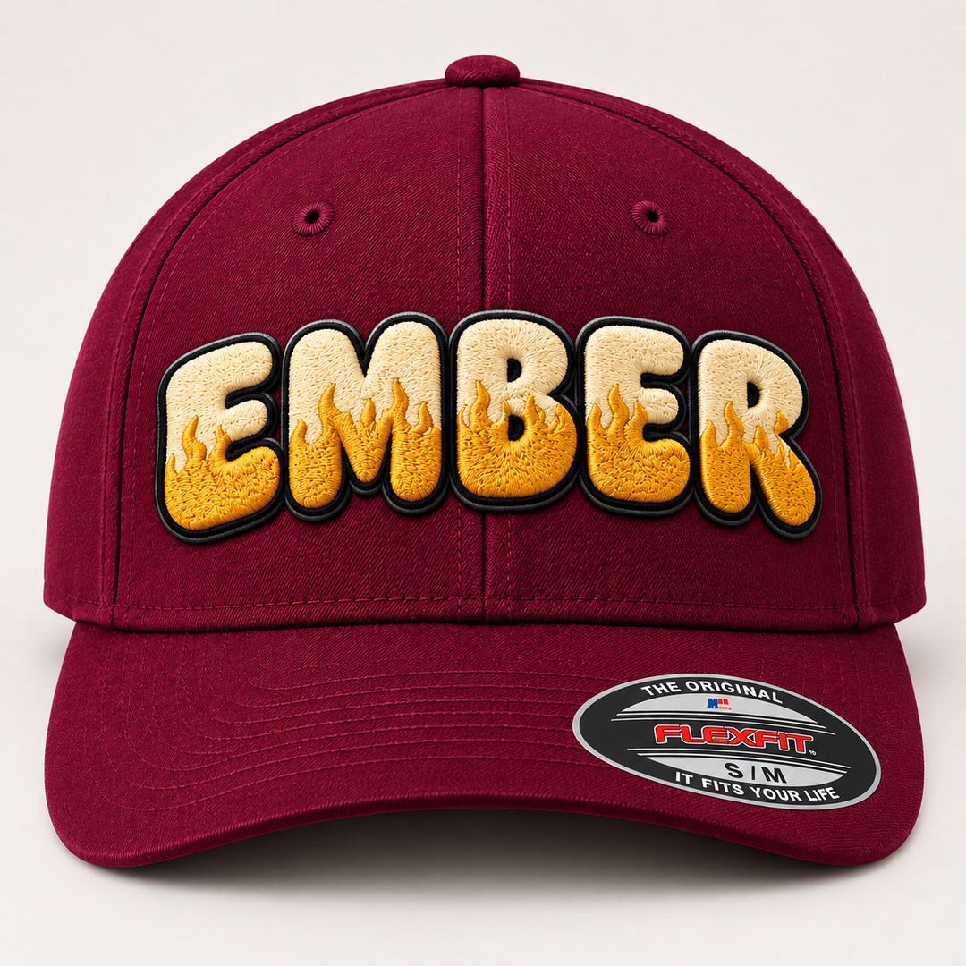 🔥🍷 Molten Silk – Inferno Pop Custom Cap Font · Cream fill · Gold flame · Black outline · Burgundy Flexfit | Hand Finished in Dubai | EmbroMania