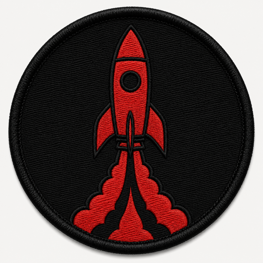 Rocket Launch embroidery patch featuring a rocket launching upward with a simple flame trail in flat red and black | Hand Finished in Dubai | EmbroMania