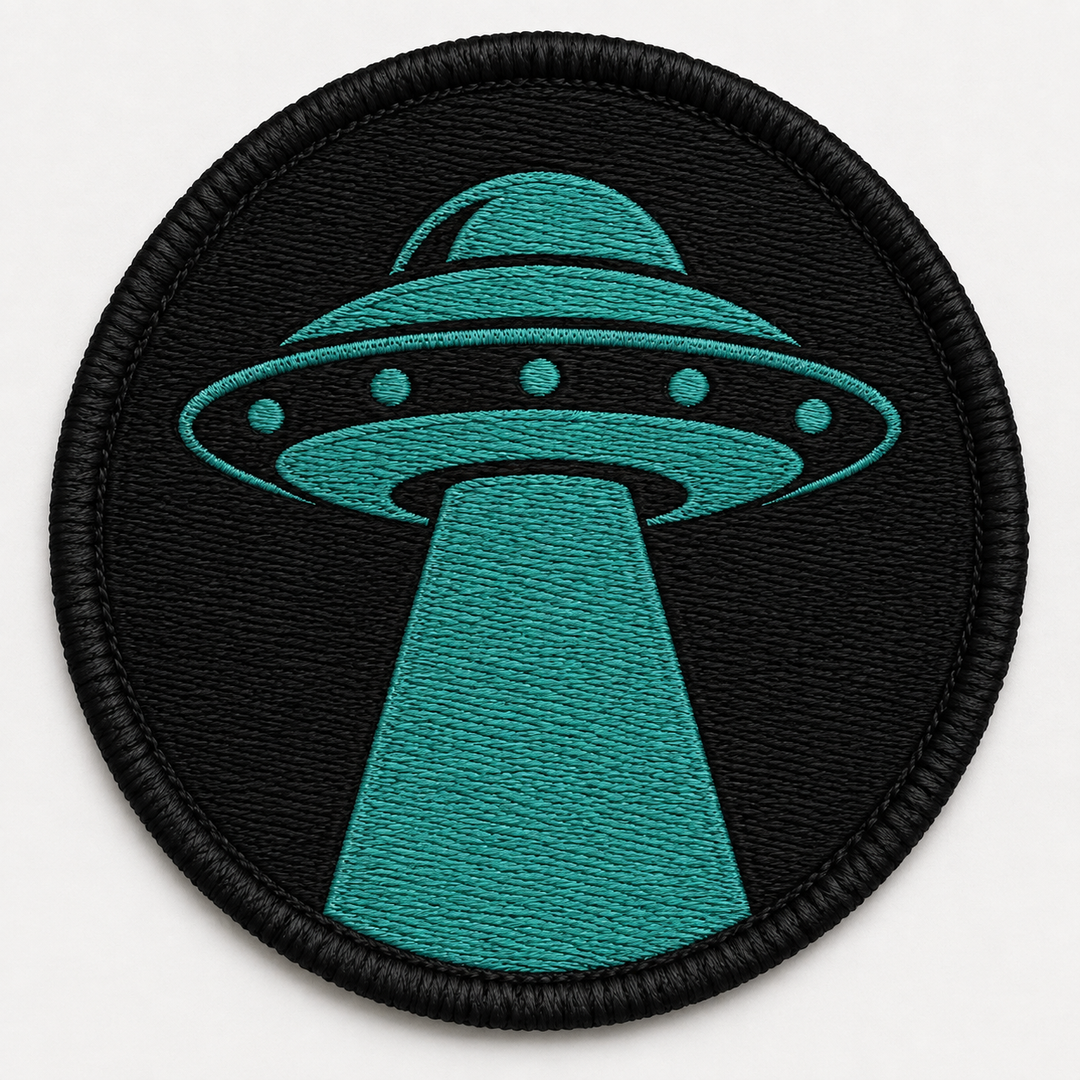 UFO Beam embroidery patch featuring a saucer shape with a single beam of light shining down in flat black and teal | Hand Finished in Dubai | EmbroMania