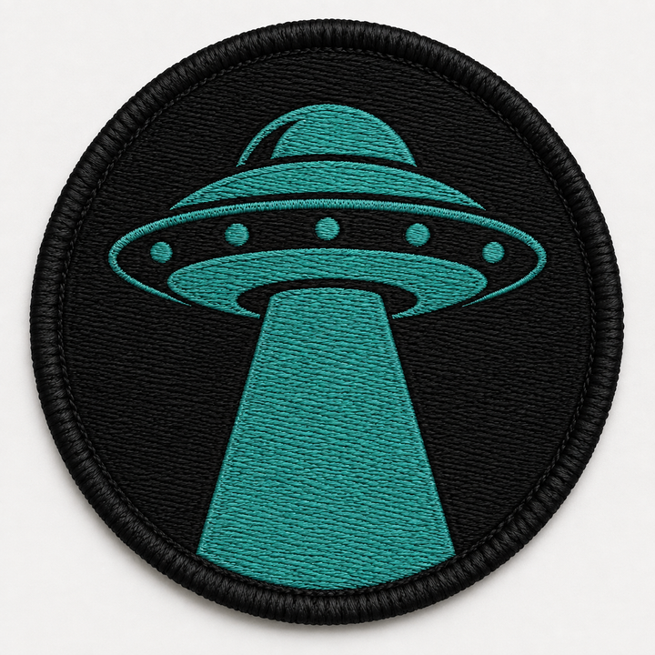 UFO Beam embroidery patch featuring a saucer shape with a single beam of light shining down in flat black and teal | Hand Finished in Dubai | EmbroMania